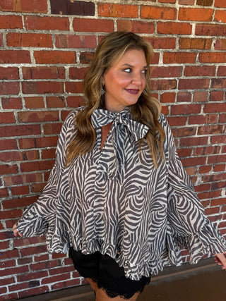 Blouse in Zebra, featuring a lightweight, oversized poncho silhouette and cascading ruffle trim
