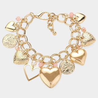Gold and pink charm bracelet with heart and round pendants.