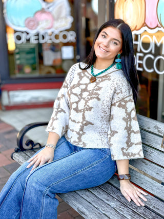 cropped knit sweater in oatmeal, featuring a two-tone abstract floral jacquard pattern, a relaxed boat neckline, and wide flared sleeves