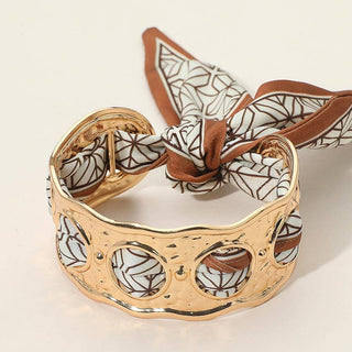 Gold bracelet with a patterned scarf 