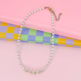 Necklace with white beads and crystal-like elements.