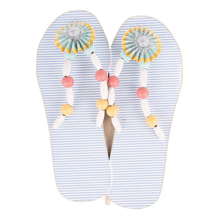 Pair of flip-flops topper with decorative straps.