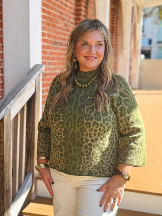 A green leopard-print mock-neck top with three-quarter sleeves.
